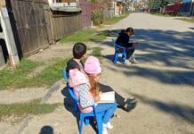 Un copil care citește în timp ce așteaptă microbuzul. La școală, învățătoarea a creat un colț de lectură: „Am decis să fac Rai cu ce am”