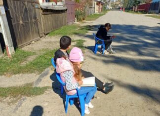 Un copil care citește în timp ce așteaptă microbuzul. La școală, învățătoarea a creat un colț de lectură: „Am decis să fac Rai cu ce am”